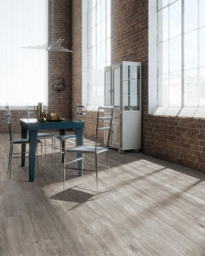 Loft con pareti in mattoni e pavimento in gres effetto legno grigio posato a correre